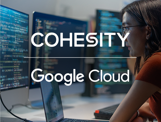 Cohesity and Google Cloud logo lockup over woman looking at 3 computer screens