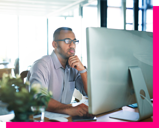 Person wearing glasses working at a computer in an office