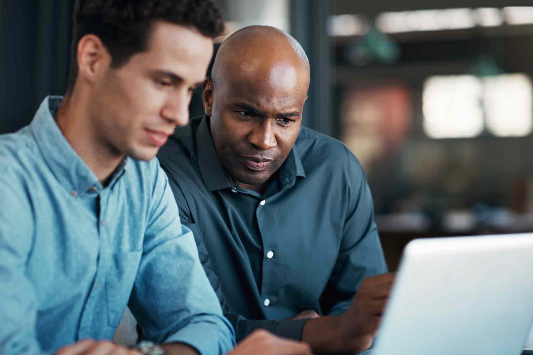 Teamwork, laptop and planning with a black man and business employee working together as a team in their office. Collaboration, internet and strategy with a manager and intern at work on a project